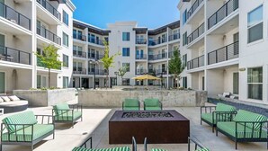 A courtyard with outdoor seating, a fire pit, and a central planter. - Stylish 2-Bedroom with Parking, Near Temple Square (Salt Lake City)