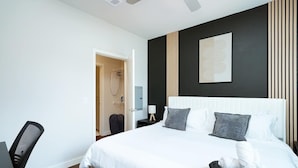 Een moderne hotelkamer met een groot bed, een bureau en een kledingkast.