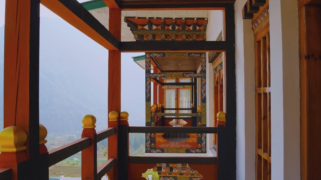 A traditional building with a balcony, wooden railings, and intricate designs.