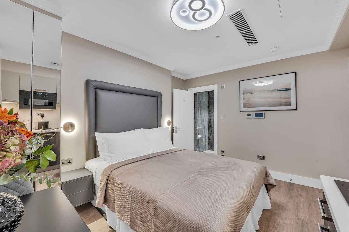 Una moderna camera d'albergo con un letto grande, un comodino e uno specchio.
