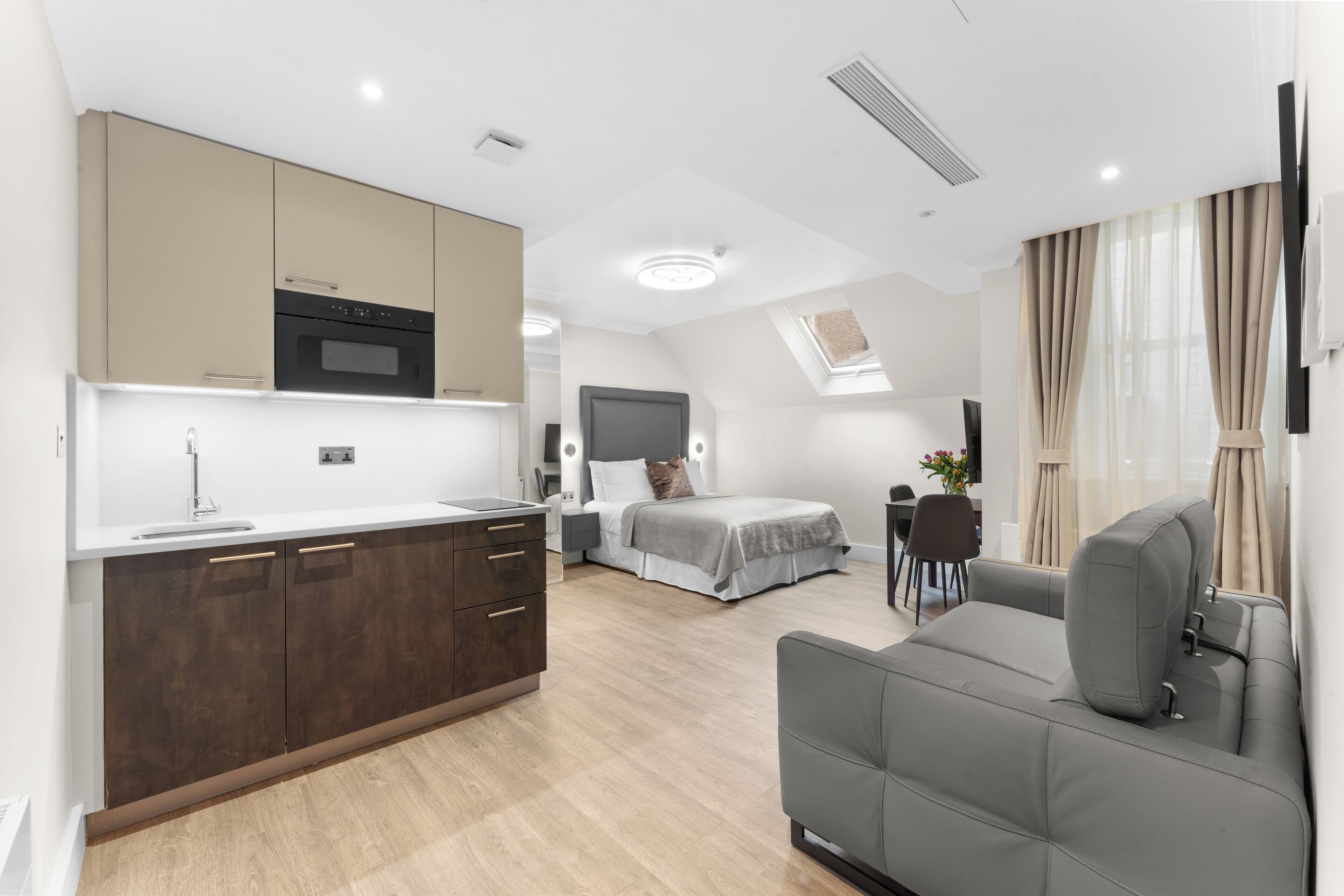 A modern apartment with a kitchen, a dining area, a living room, and a bedroom.