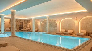 Ein Spa-Bereich mit Liegestühlen und einer Steinwand.