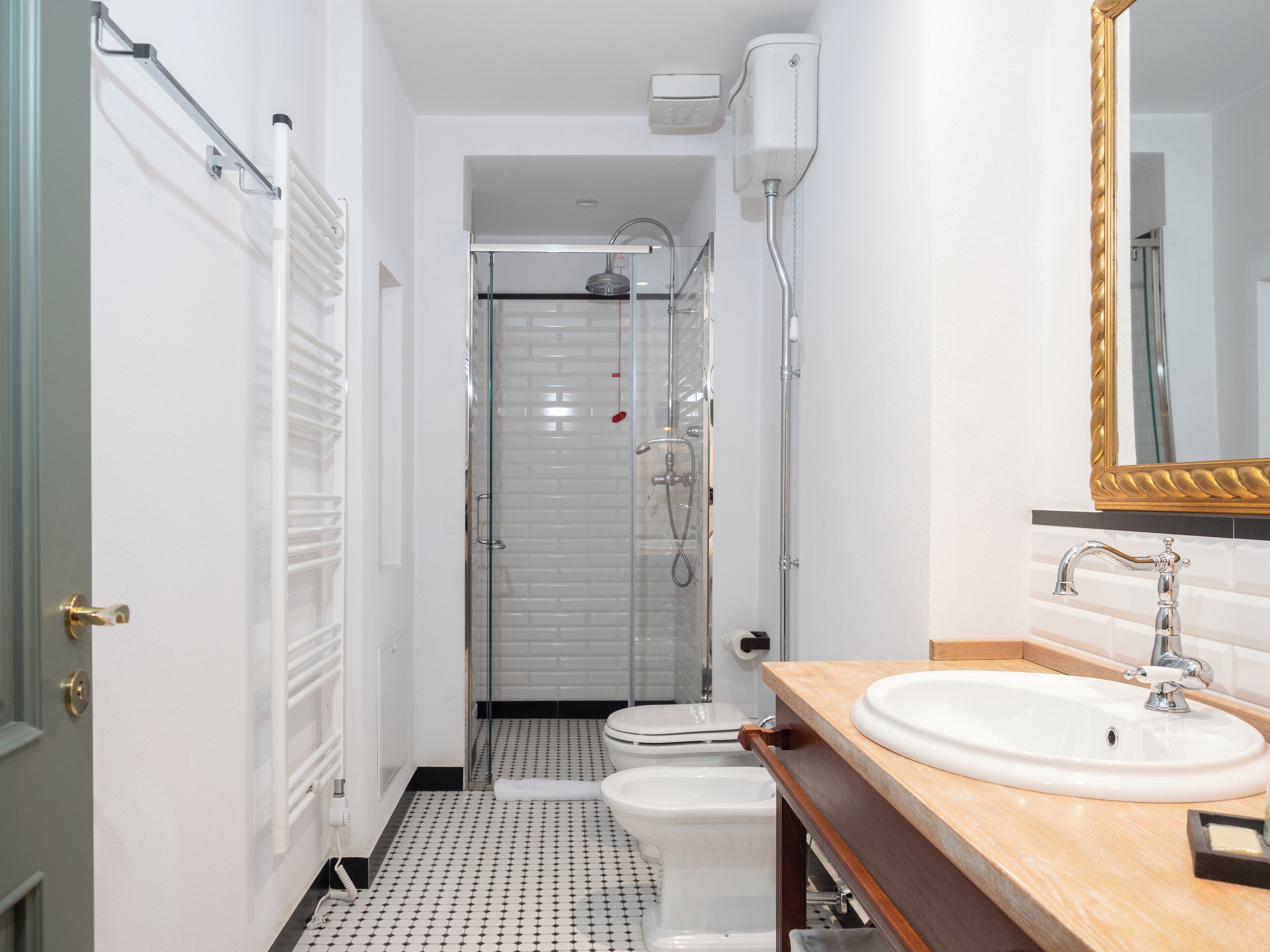 A bathroom with a white sink, a mirror, and a shower.