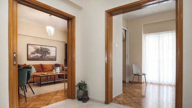 A spacious living area with a sofa, chairs, a coffee table, and a painting on the wall. - Neos Kosmos Gem w Acropolis View Balcony (Athens)