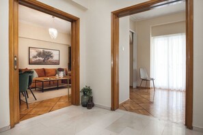 Uma sala de estar ampla com um sofá, cadeiras, uma mesa de centro e um quadro na parede.