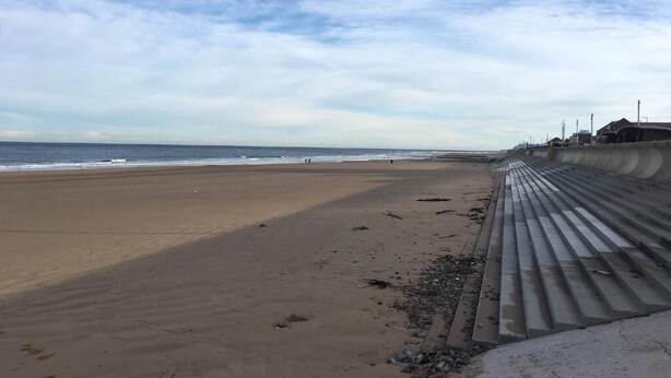 A beach with a concrete barrier and a building in the background. - The Beacon Hotel (Redcar)