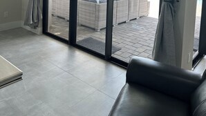 Een moderne woonkamer met een schuifglazen deur naar een terras.