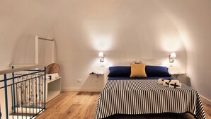 A bedroom with a bed, two bedside lamps, a blue ceiling, and a wooden floor. - Casetta Di Laura In Massa Lubrense (Massa Lubrense)