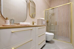 Un bagno moderno con un mobile lavabo, un water e uno spazio doccia.