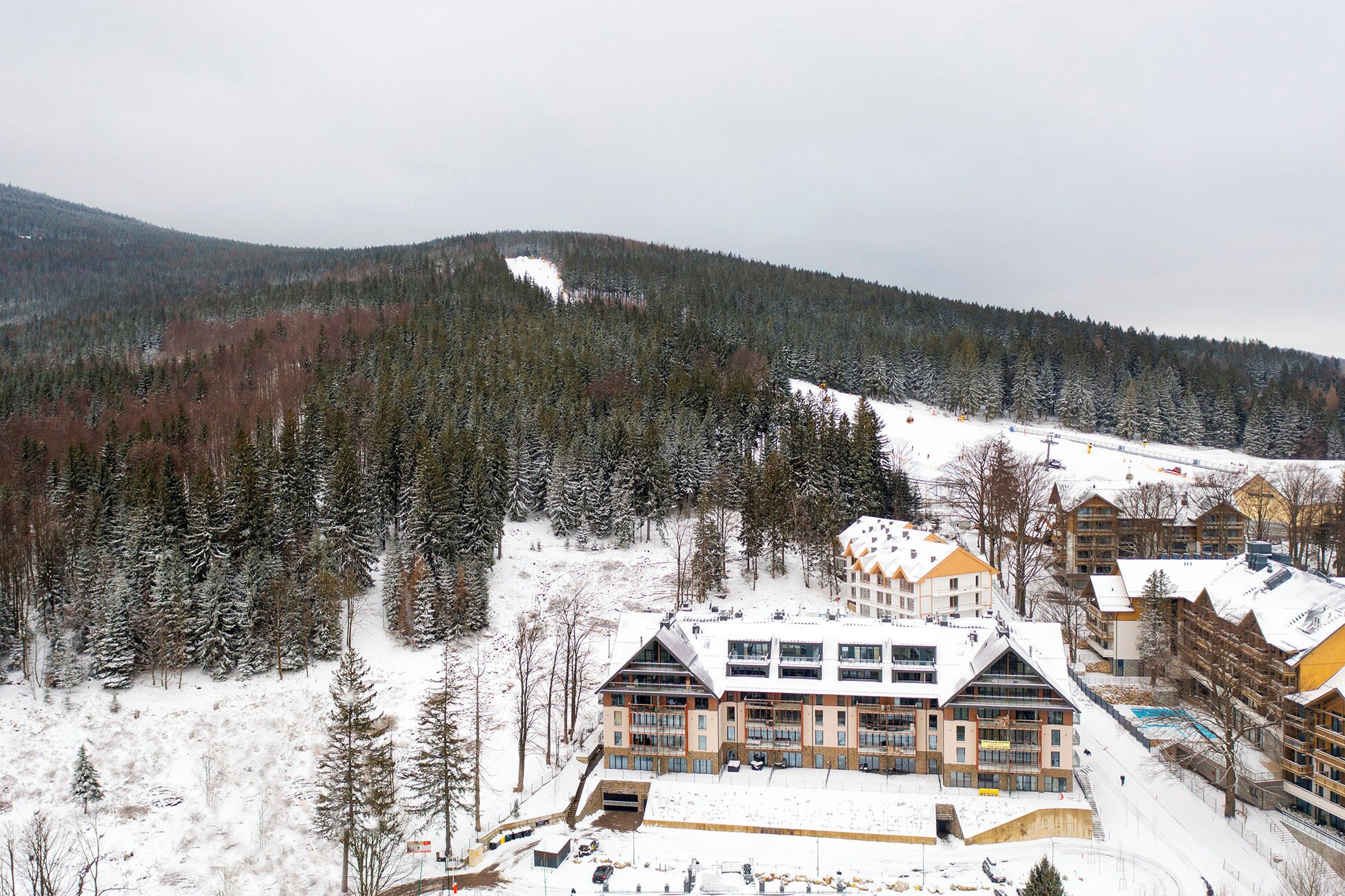 A snow-covered mountain with a ski resort and buildings.