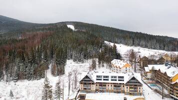 A snow-covered mountain with a ski resort and buildings.