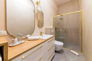 A modern bathroom with a wooden vanity, a large mirror, a glass shower enclosure, and a toilet. - RentPlanet - Źródło Izery (Swieradow-Zdroj)