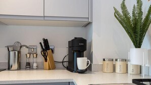Una cocina moderna con cafetera, utensilios y recipientes de almacenamiento.
