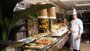 A buffet with various food items and a chef standing beside it. - Faraj Al Madina Hotel (Madinah)