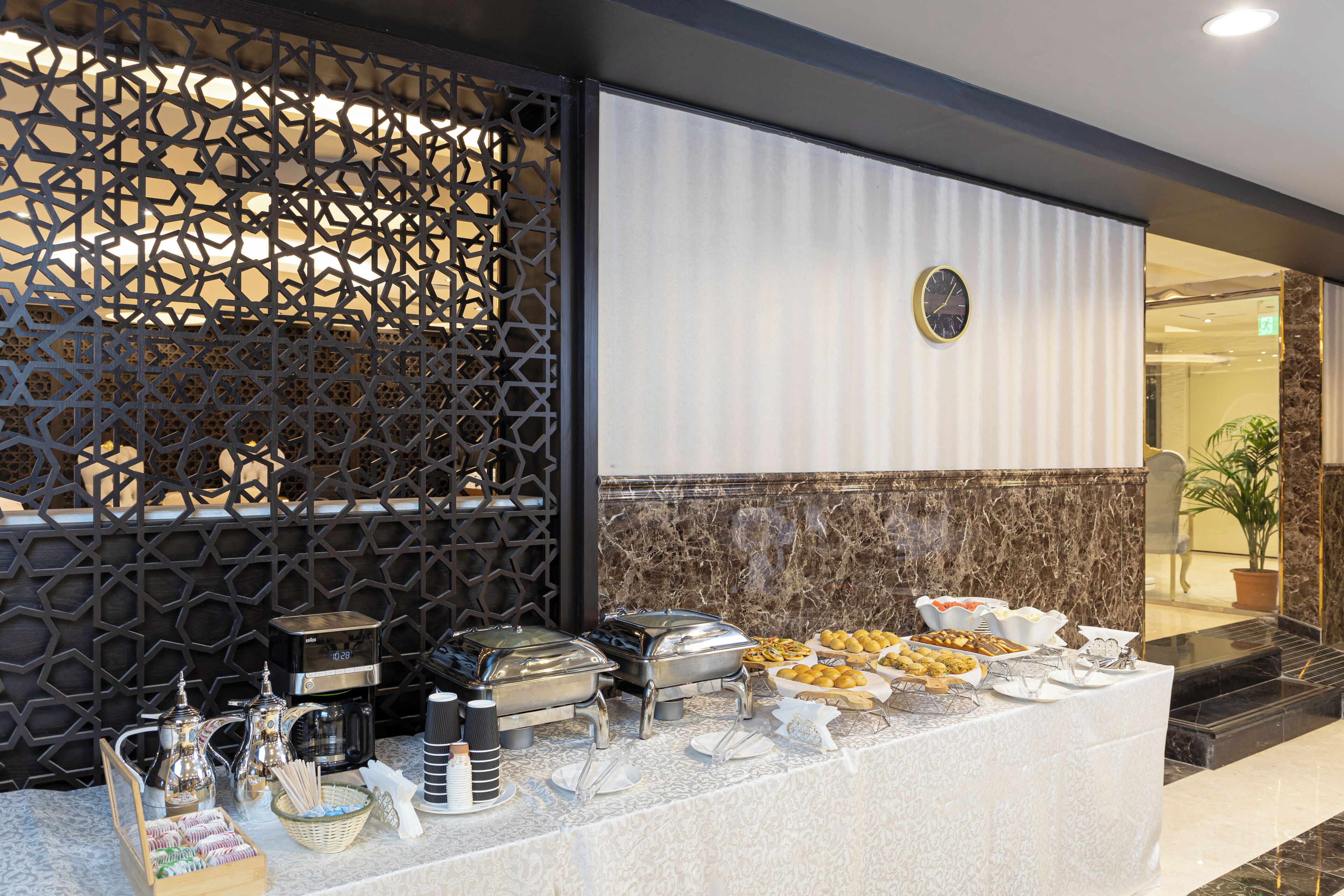 A buffet setup with various food items and a coffee station.