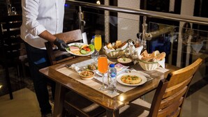 A dining table set with various dishes, a glass of orange juice, and a bottle of water. - Faraj Al Madina Hotel (Madinah)