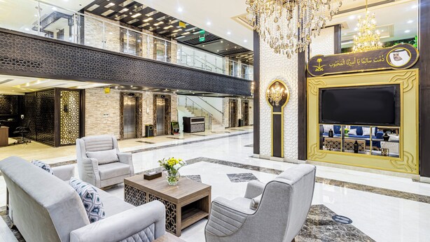 A spacious lobby with a high ceiling, a chandelier, and a seating area with sofas and a coffee table. - Faraj Al Madina Hotel (Madinah)