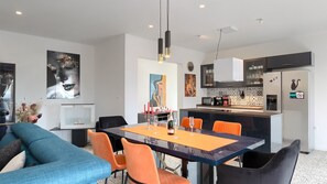 A modern kitchen with a microwave, coffee maker, and refrigerator. There is a dining area with a table and chairs. - Villa Rhapsody by Villas Guide (Buzet)