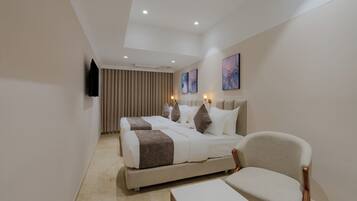 A hotel room with a bed, two bedside tables, a chair, a flat-screen TV, and artwork on the walls.