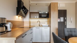 A compact kitchenette with a built-in oven, a coffee maker, and a sink. - RentPlanet - Holiday Mountain Residence (Swieradow-Zdroj)