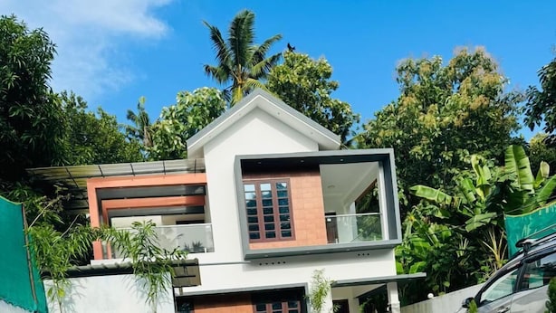 A modern two-story house with a swimming pool in the foreground. - Explore Private Pool Villa Varkala (Varkala)