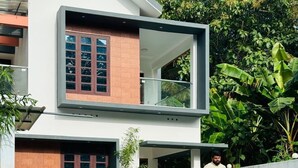A modern two-story house with a swimming pool in the foreground. - Explore Private Pool Villa Varkala (Varkala)