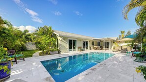 A swimming pool with a patio area, surrounded by palm trees and a house. - 2 Mi to Deerfield Beach: Home w/ Outdoor Oasis! (Deerfield Beach)