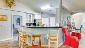 A spacious kitchen with a central island, white cabinets, and a red chair. - 4 Mi to Beach: Family-friendly Home in Navarre (Navarre)