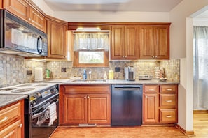 A kitchen with wooden cabinets, a stainless steel dishwasher, a built-in oven, and a microwave. - 11 Mi to Dtwn Columbus: Peaceful Townhome w/ Yard! (Columbus)