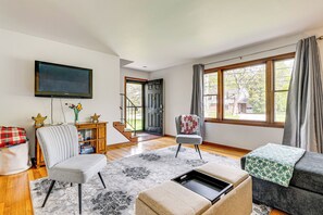 A modern living room with a flat-screen TV, a grey armchair, a sofa, and a coffee table. - 11 Mi to Dtwn Columbus: Peaceful Townhome w/ Yard! (Columbus)