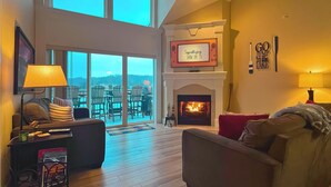 A spacious living room with a fireplace, a sofa, a coffee table, and a TV. - Lakefront Camdenton Condo Near Ha Ha Tonka (Camdenton)