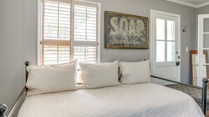 Un dormitorio con una cama grande, una puerta con espejo y un cuadro en la pared.