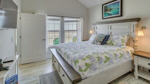 Ein Schlafzimmer mit Bett, Nachttisch, Lampe, Fenster und Tür.