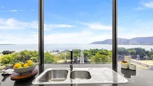 Una cocina con un amplio ventanal que ofrece vistas panorámicas de un lago y montañas.