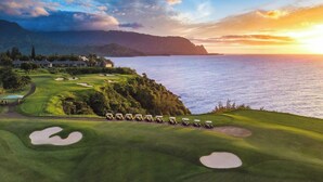 A golf course with bunkers, a water body, and distant mountains. - The Cliffs Condos (Princeville)