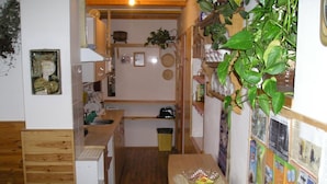 A narrow kitchen with wooden cabinets, a sink, and a dining table with a placemat.