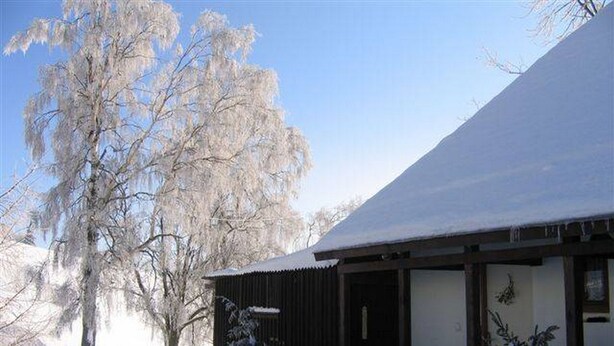 A snow-covered building with a wooden exterior and a covered porch area. - Apartment Pavla With 3 Bedrooms and 1 Bathrooms (Jachymov)