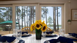 A dining table set for four with a view of a lake and trees. - Minutes from Downtown St. Michaels | Private Boat Ramp | Dock (Bozman)