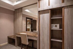 Una habitación de hotel con un escritorio de madera, una silla y un minibar.