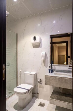 Combined shower/bathtub, hair dryer, slippers, towels