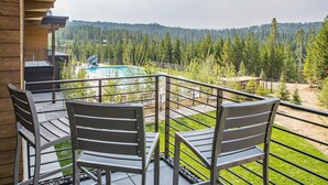 Ein Balkon mit zwei Metallstühlen und einem Pool.