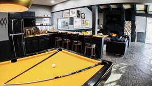 A pool table with a yellow felt surface, a billiard cue, and a white cue ball.