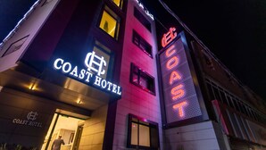 The exterior of the Coast Hotel with a prominent neon sign and a visible entrance. - Coast Hotel (Boumerdès)