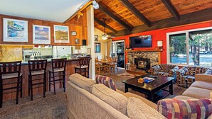 A cozy living room with a fireplace, a bar area, and a dining space. - Horizons 4 | Year-Round Outdoor Activities! (Mammoth Lakes)