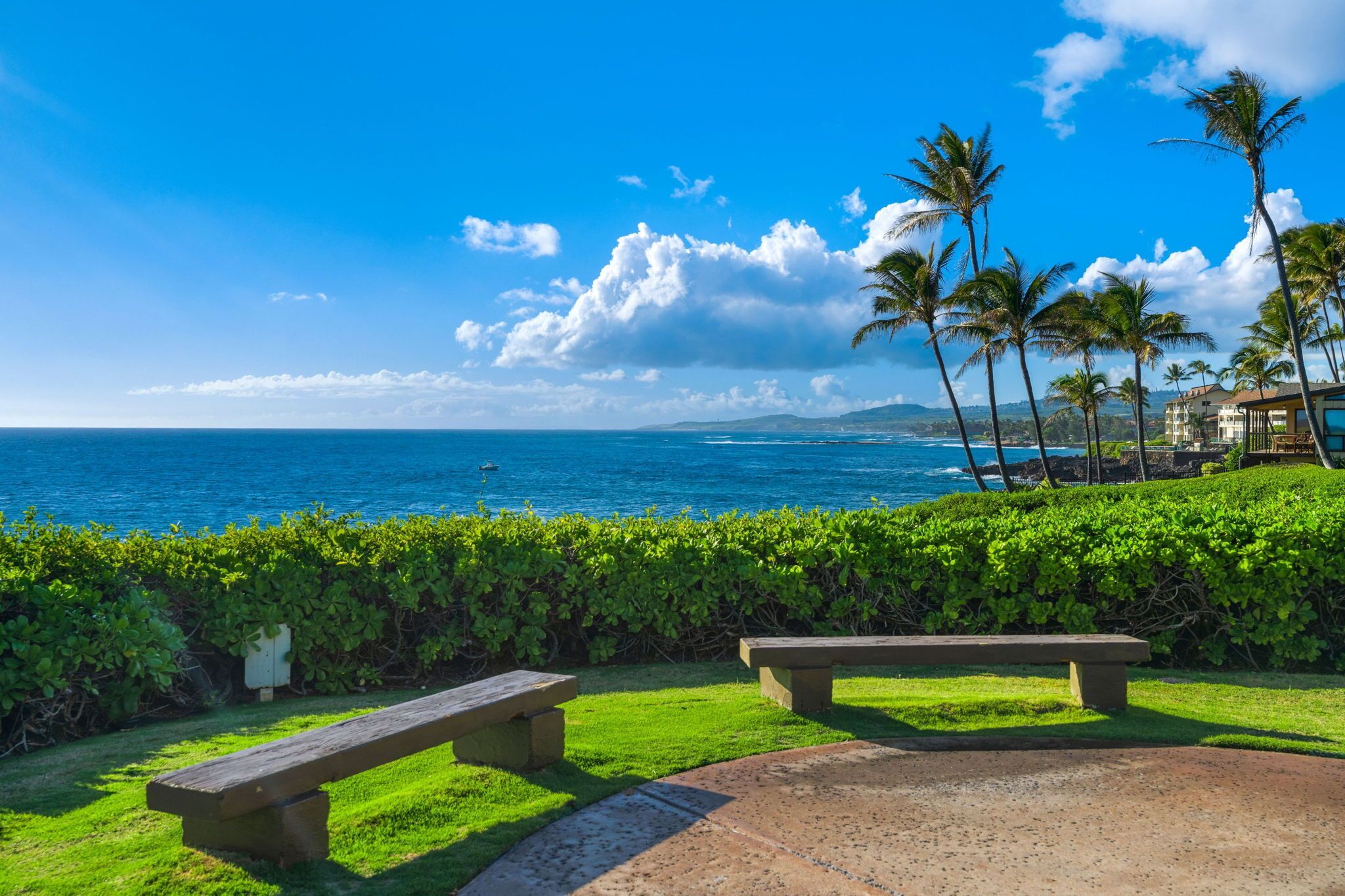 A coastal view with a bench and a clear sky.