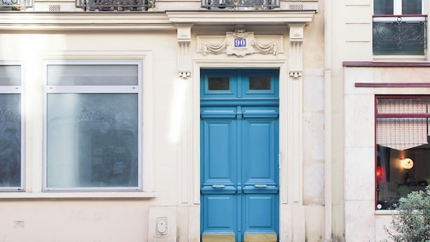 A building facade with a blue door, a number plaque, and a window with a metal balcony. - Cozy apartment - close to Montmartre (Paris)