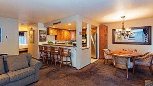 A compact living space with a kitchenette, a dining area, and a sofa.