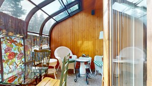 A cozy, wooden interior with a curved ceiling, a glass door, and a table with chairs. - Mins to Lodge & Ski Shuttle | Parking for 2 (Mammoth Lakes)