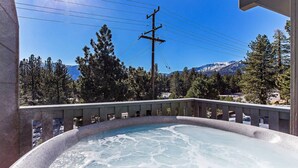 A hot tub with a view of mountains and trees.