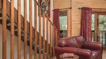 A wooden staircase with a red leather sofa and a small table with books.